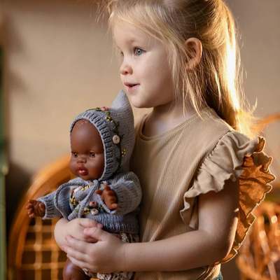 Petite fille qui joue avec une poupée minikane